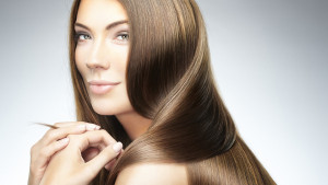 Close-up, beauty portrait of a young brunette woman with beautiful straight hair. Shallow DOF. Developed from RAW; retouched with special care and attention; Small amount of grain added for best final impression. Adobe RGB color profile.